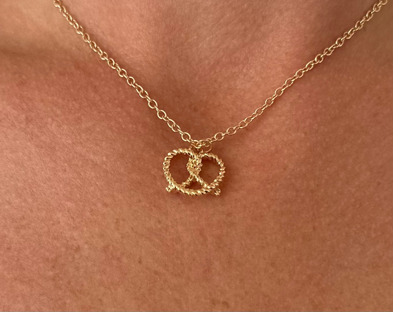 Gold-colored metal necklace with a twisted Heart