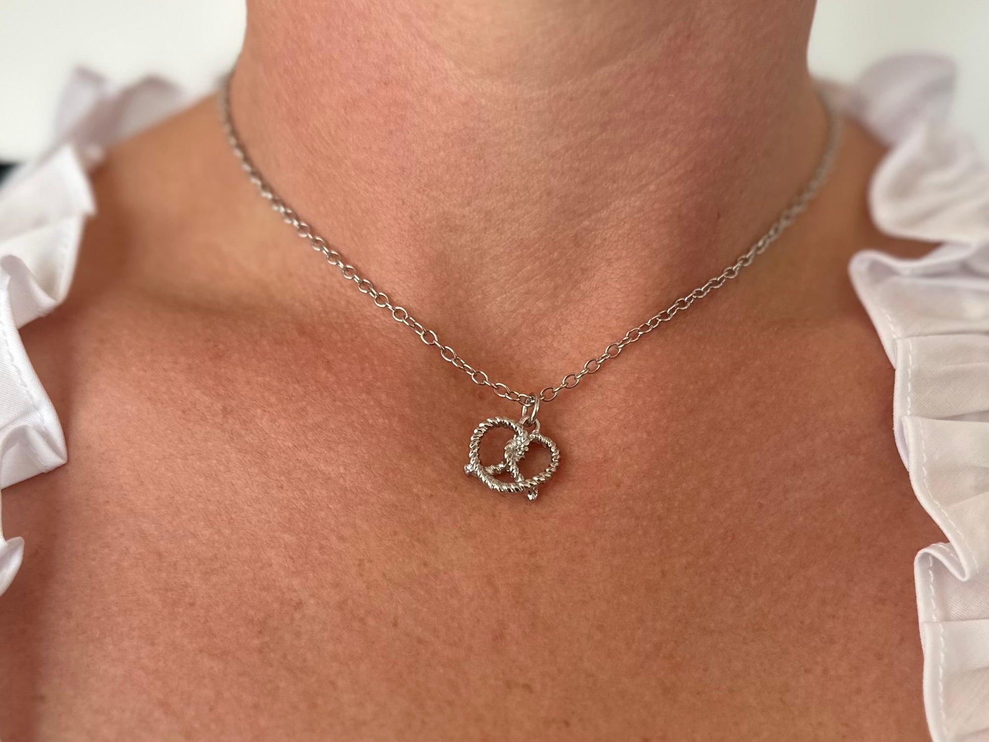 Silver-colored metal necklace with a twisted Brezel